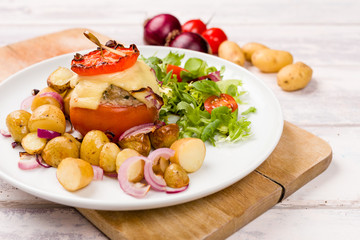 Oven baked tomatoes stuffed with minced meat, cheese and herbs. Served with new potatoes and salad.