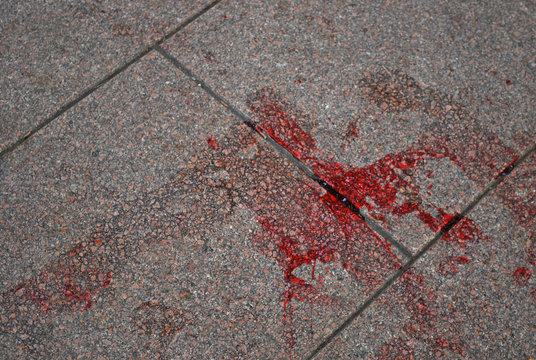 Blood left on a tile at the place of crime scene. Stain on old granite texture
