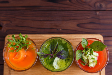 Diet concept, healthy lifestyle, low calorie detox and dietary food. Set of blended vegetable smoothies in glasses on kitchen table with free space for text design
