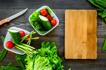 Healthy meal with vegetables tomato, cucumber, asparagus in cotainers on wooden background top view mockup