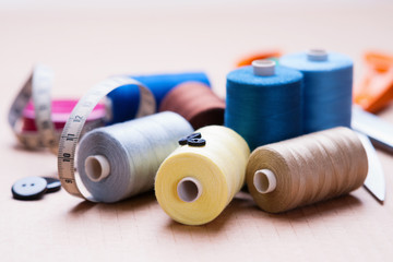 Pile of colorful spools of thread, buttons and measuring meter 