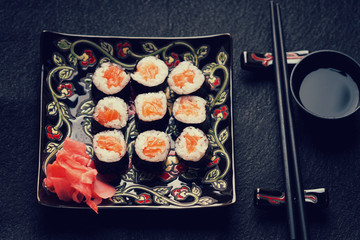 Sushi rolls with salmon, ginger, chopsticks and soy sauce 