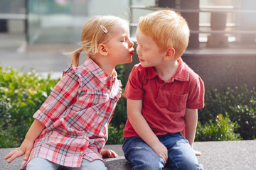 Group portrait of two white Caucasian cute adorable funny children toddlers sitting together...