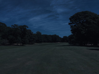 Long view down the fairway of a golf course hole on a beautiful summer night