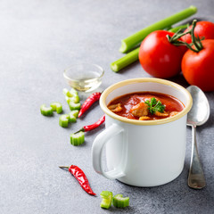 Delicious homemade tomato soup with meatballs in enamel mug. Healthy food concept with copy space.