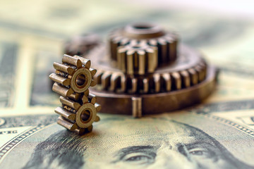 metal gears on dollar banknotes