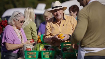  Senior couple shopping at a farmers market - Powered by Adobe