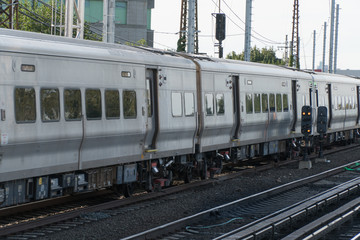 Obraz premium Commuter railroad train traveling on track during rush hour carry passengers from work to home station. Day time outside motion blur photo