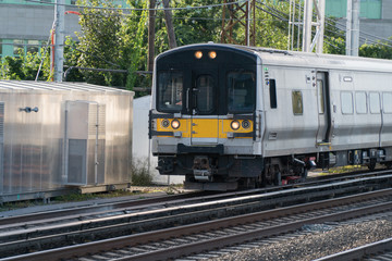 Generic electric power passenger commuter train on tracks carry people home and work for rush hour. Day time outside photo