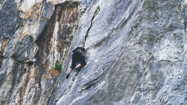 Extreme rock climber climbs difficult route on the mountains. 3840x2160