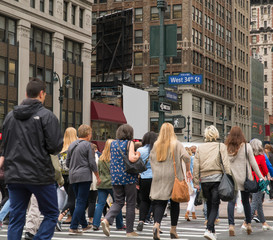 People walk across a busy Manhattan crosswalk in New York City during rush hour evening commute travel to work and home