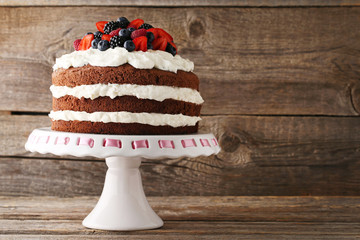 Delicious chocolate biscuit cake with berries on cake stand