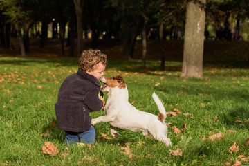 Family fun at fall (autumn) public park with children and pets dog