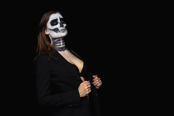 portrait beautiful of brown-haired woman with Halloween skull make up in a stylish black jacket and bra over black background.