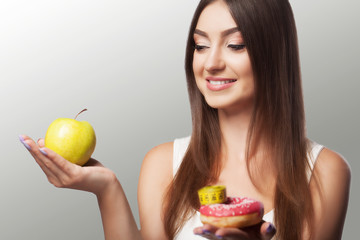 Diet. A young girl adheres to the diet. Choosing between an infusion or overeating. The concept of health and beauty. On a gray background.