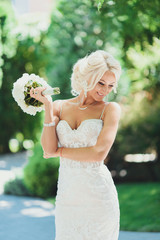 Portrait of a beautiful blonde bride with wedding bouquet of peony 