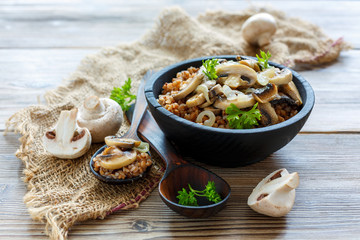 Bowl with buckwheat porridge and fried mushrooms.