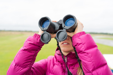 blonde woman looks in binocular