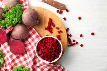 Composition with sliced beetroot on white wooden background