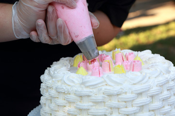 Person decorating cake with cream