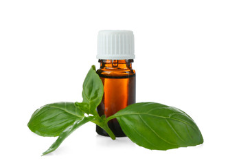 Bottle with oil and green basil leaves on white background