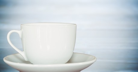 White cup against blurry blue wood panel