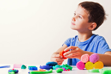 Boy playing and creating from modeling clay or plasticine