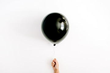 Halloween concept. One black balloon in girl's hand. Flat lay, top view.