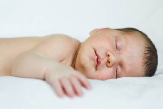 Newborn Baby Girl Sleeping on Soft White