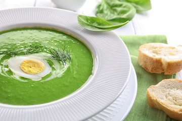 Delicious spinach soup in plate on table