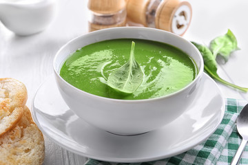 Bowl with tasty spinach soup on table