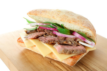 Steak sandwich and wooden board on white background