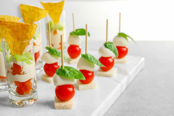 Tasty canapes and appetizers for baby shower party on table