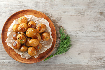 Pile of baked potatoes on wooden tray