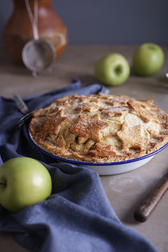 Homemade apple pie cooling on a table.