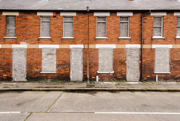 Fototapeta na wymiar Bricked up and abandoned town houses in a run-down inner city street in Belfast
