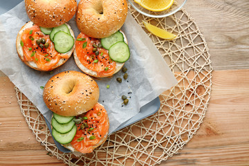 Composition with tasty salmon bagels on table