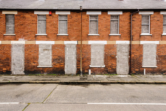 Bricked up and abandoned town houses in a run-down inner city street in Belfast