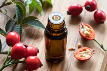 A bottle of rosehip seed oil on a wooden table