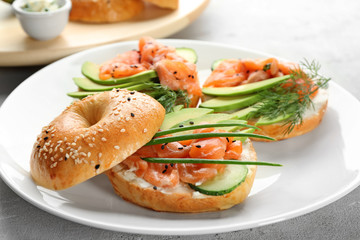 Delicious salmon bagels on plate, closeup
