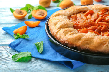 Delicious apricot cake on table
