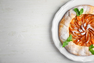 Delicious apricot cake on wooden background