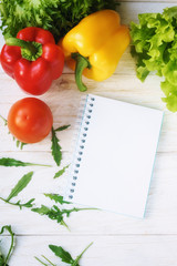 Obraz na płótnie Canvas bell pepper, green salad and notepad