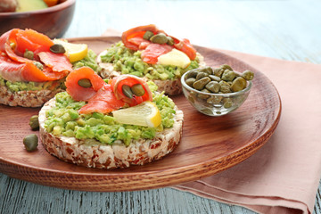 Tasty crispbread sandwiches with salmon and avocado on plate