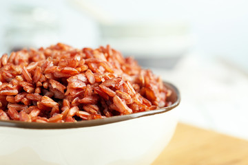 Bowl with red rice on board, closeup