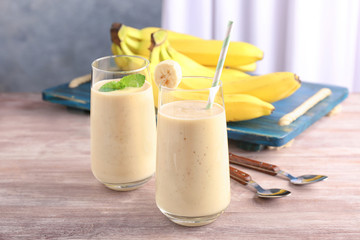 Glasses with delicious banana smoothie on wooden table