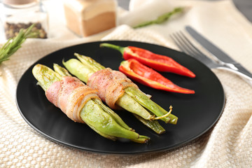 Plate with delicious bacon-wrapped green beans on fabric