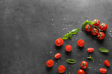 Fresh cherry tomatoes and basil on grey background