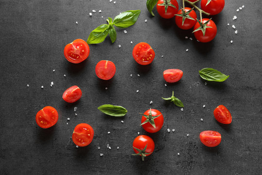 Fresh cherry tomatoes and basil on grey background