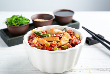 Bowl with brown rice and vegetables on wooden table